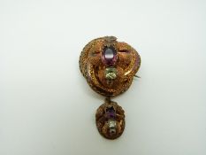A Victorian pinchbeck brooch in a knot design with foliate detail set with foiled amethysts and
