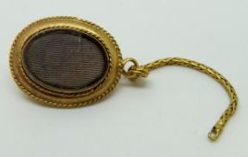 A pinchbeck locket set with paste, with engraved foliate decoration and glass compartment, 2 x 1.