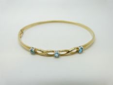 A 9ct gold bangle set with blue topaz, 4.