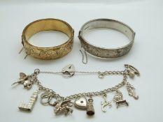 A silver charm bracelet with 11 charms, a hallmarked silver bangle and a rolled gold bangle.