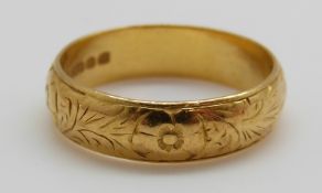 A 22ct gold wedding band with chased decoration, 6.