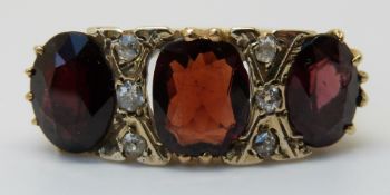 An 18ct gold ring set with large garnets and diamonds (size R )