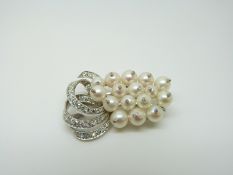 A platinum brooch set with 15 pearls, each with a diamond to the centre,