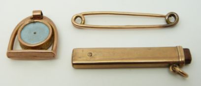 A 9ct gold pendant in the form of a stirrup, a 9ct gold safety pin,