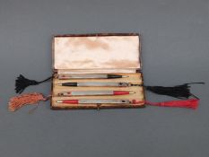 A cased set of four white metal bridge pencils, marked sterling silver,