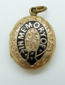 A Victorian locket reading 'In memory of' in black enamel with chased foliate design