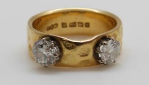 An 18ct gold ring set with two diamonds each measuring approximately 0.
