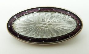 A silver brooch set with enamel