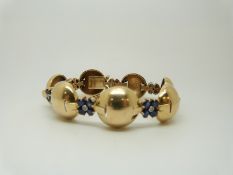 A Tiffany & Co bracelet set with diamonds and sapphires in flower clusters between gold spheres