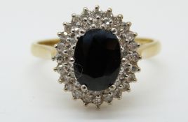 An 18ct gold ring set with a sapphire surrounded by two rows of diamonds (size N)
