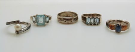 Two silver rings set with blue topaz, a silver ring set with a sapphire,