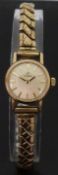 Omega gold plated ladies wristwatch with gold hands and baton markers and white face,