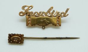 A yellow metal Edwardian brooch set with seed pearls reading 'snowbird' marked 1926 and a Victorian