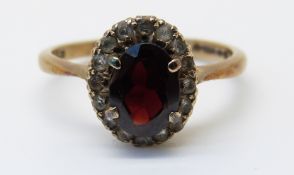 A 9ct gold ring set with a garnet and paste (size M)