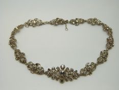 An early 20thC white metal necklace of floral design set with foiled paste