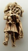 A 9ct gold charm in the form of a bagpipe player, 5.