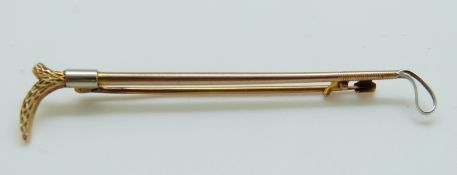 A 9ct and 18ct gold tie pin in the form of a riding crop 6cm, 2.