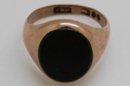 A 9ct gold signet ring set with a blood stone cabochon, 4.