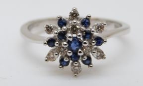A 9ct white gold ring set with sapphires and diamonds in a cluster