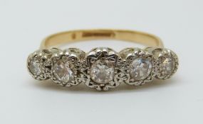 An 18ct gold ring set with five diamonds in an illusion setting, the centre stone approximately 0.