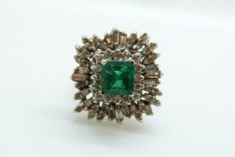 An 18ct white gold ring set with a square cut emerald of approximately 1ct surrounded by baguette