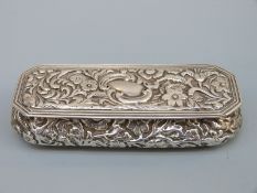 An Edward VII hallmarked silver repoussé decorated snuff box or dressing table, Birmingham 1901,
