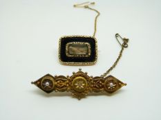 A Georgian mourning brooch set with plaited hair to the centre surrounded by black enamel and gold