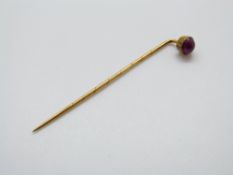 A Victorian stick pin set with a ruby cabochon, 5.7cm (ruby cabochon 5.