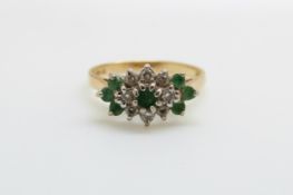 An 18ct gold ring set with emeralds and diamonds in a cluster (size K/L)