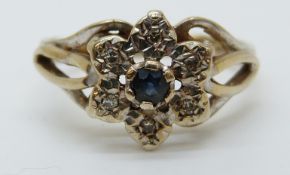 A 9ct gold ring set with a sapphire surrounded by diamonds in a cluster (size K)
