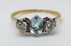 An 18ct gold ring set with an oval cut aquamarine and two diamonds, each approximately 0.