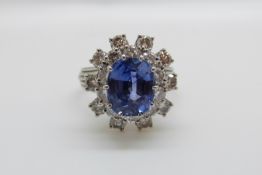 A platinum ring set with a cushion cut cornflower blue sapphire of approximately 5.