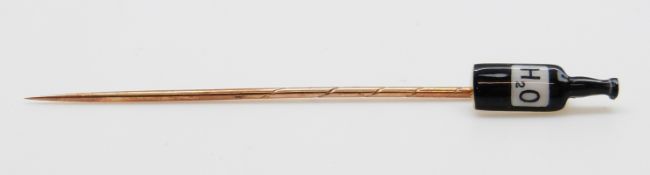 A yellow metal stick pin in the form of an H2O bottle, 6.