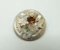 A hallmarked silver Scottish brooch in the form of a thistle set with an orange stone,