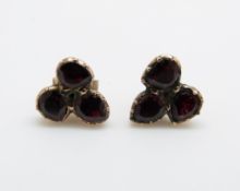 A pair of early Victorian earrings set with three foiled garnets to each