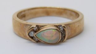 A 9ct gold ring set with a pear cut opal and diamonds (size M)