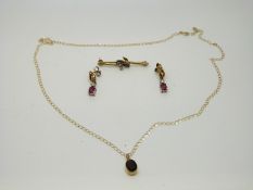 A 9ct gold brooch set with two sapphires and a diamond,