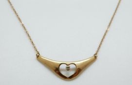 A 9ct gold necklace set with a diamond in a heart shape, 1.