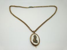 A Victorian pendant/ brooch set with a silhouette miniature with gilt finish on a Victorian gilt