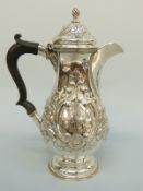 An Edward VII hallmarked silver hot water jug with repoussé decoration, Chester 1904, height 23.