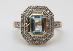 A 9ct gold ring set with a topaz surrounded by diamonds in a rectangular setting (size M)