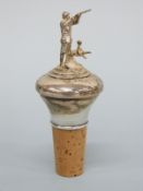 A modern hallmarked silver bottle stopper depicting a gun dog and master,