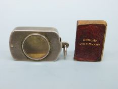 A Victorian silver novelty miniature book holder with magnifier to the swivel lid containing a