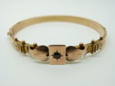 A yellow metal Victorian bangle set with a garnet