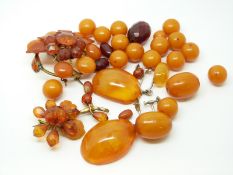 Twenty-one egg yolk coloured amber beads, the largest approximately 20x15mm,
