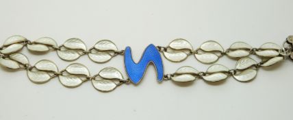 A silver bracelet of with white enamel leaves and a blue centre piece,