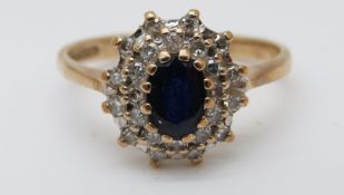 A 9ct gold ring set with a sapphire surrounded by diamonds (size N)