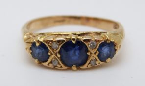 An 18ct gold ring set with three sapphires and four diamonds (size M)