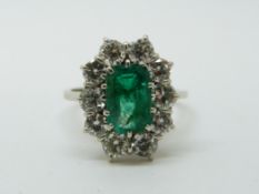 An 18ct gold ring set with an emerald cut apple green emerald of approximately 1.