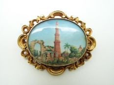 A Victorian yellow metal brooch set with a painted Indian miniature depicting Qutub Minar set with